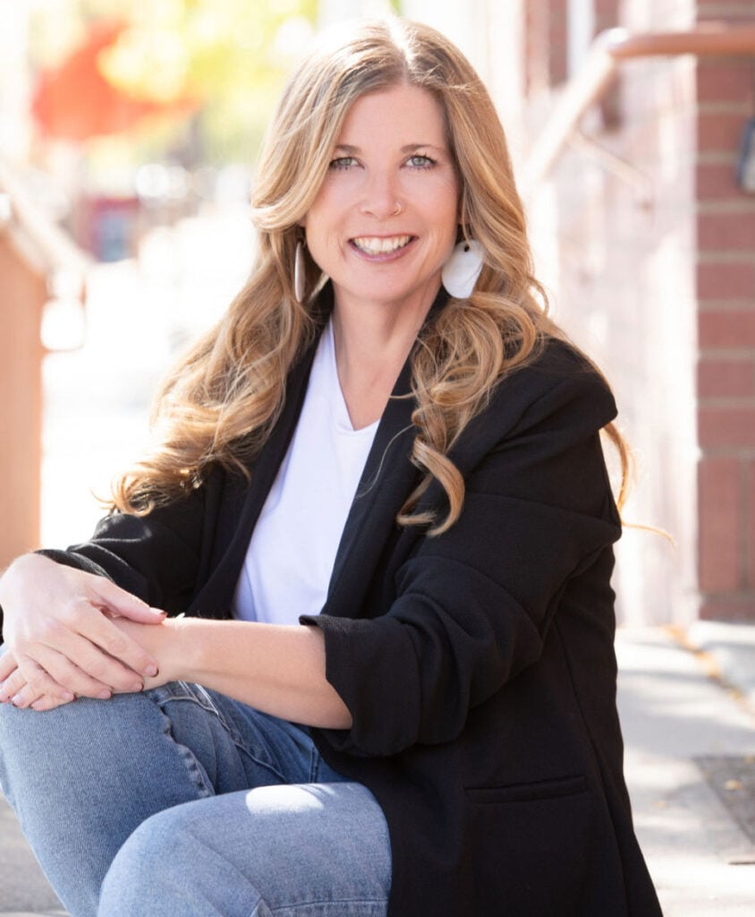 Photo of Rebekah Griffith, PT, DPT sitting outside in a black blazer and blue jeans.